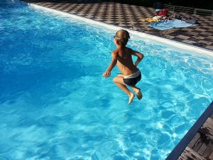 niño tirandose a la piscin